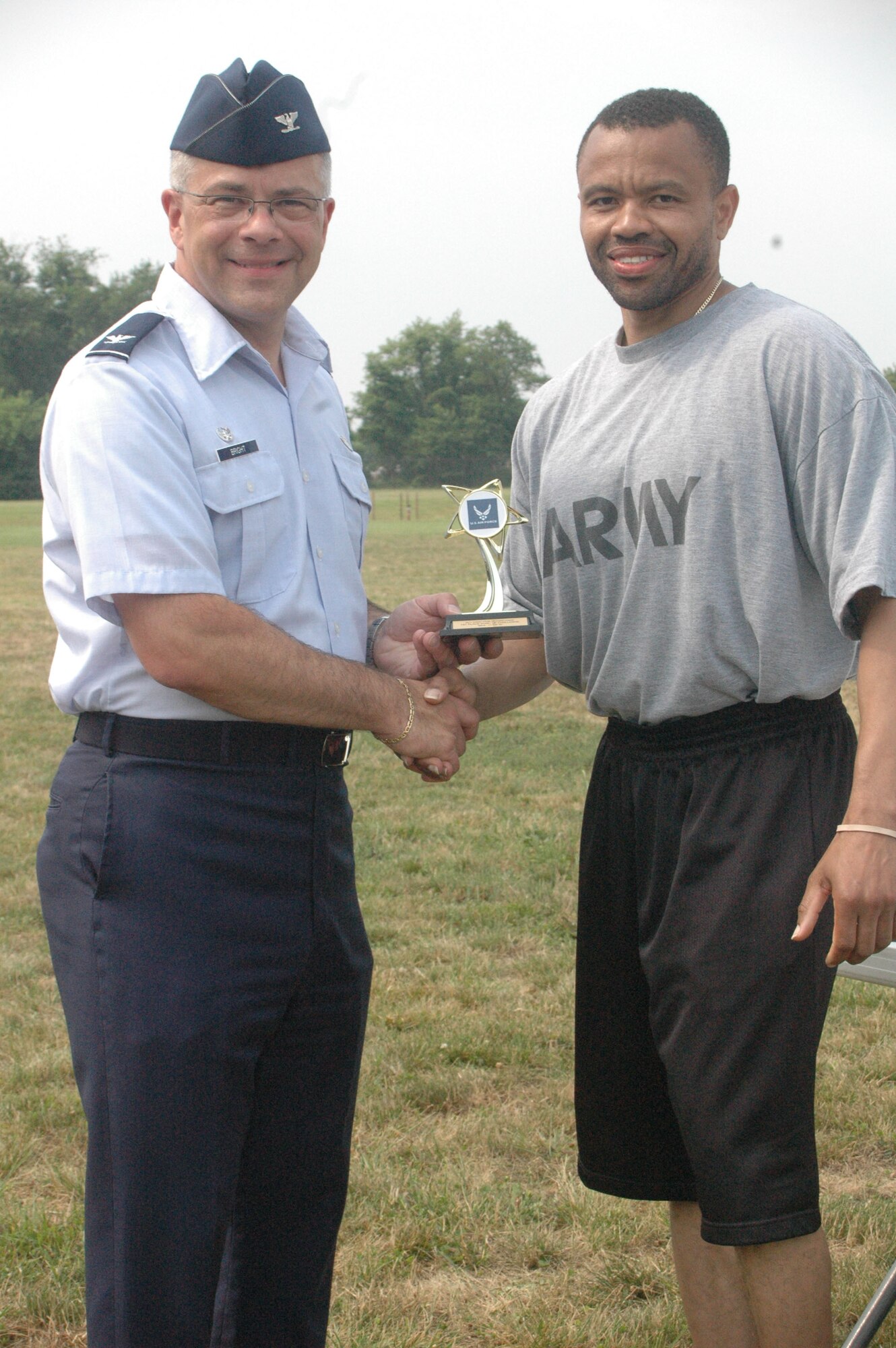 Col. Randal L. Bright, 512th Airlift Wing commander, presents Sgt. 1st Class James White, Delaware Army National Guard, with a trophy for performing 139 push-ups in two minutes, winning the mens 40 and older category at the 512th AW Fitness Challenge June 12, 2011, at the track, Dover Air Force Base, Del. Sergeant White was the only non-Air Force member to compete. (U.S. Air Force photo by Senior Airman Tanisha Brown/Released)