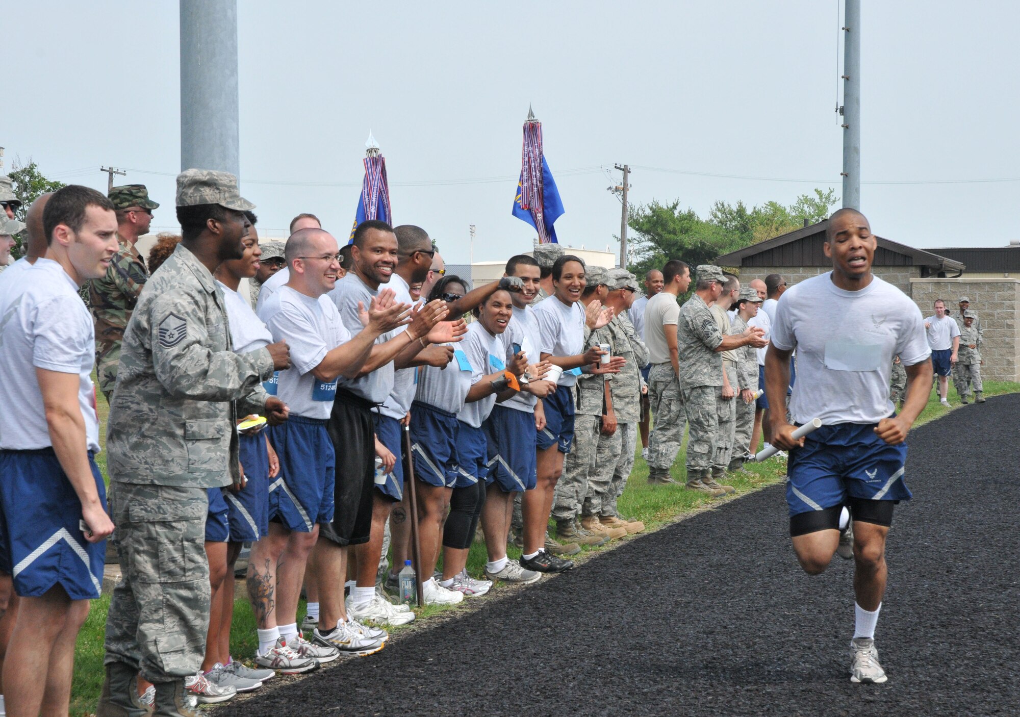 The crowd cheers as Senior Airman Brandon Bermudez, 712th Aircraft Maintenance Squadron, runs past in the quarter mile relay race June 12, 2011, as part of the 512th Airlift Wing Fitness Challenge at the track, Dover Air Force Base, Del. Airman Bermudez also competed in the sit-up competition winning his age category by performing 100 sit-ups in two minutes. (U.S. Air Force photo by Staff Sgt. Andria J. Allmond/Released)