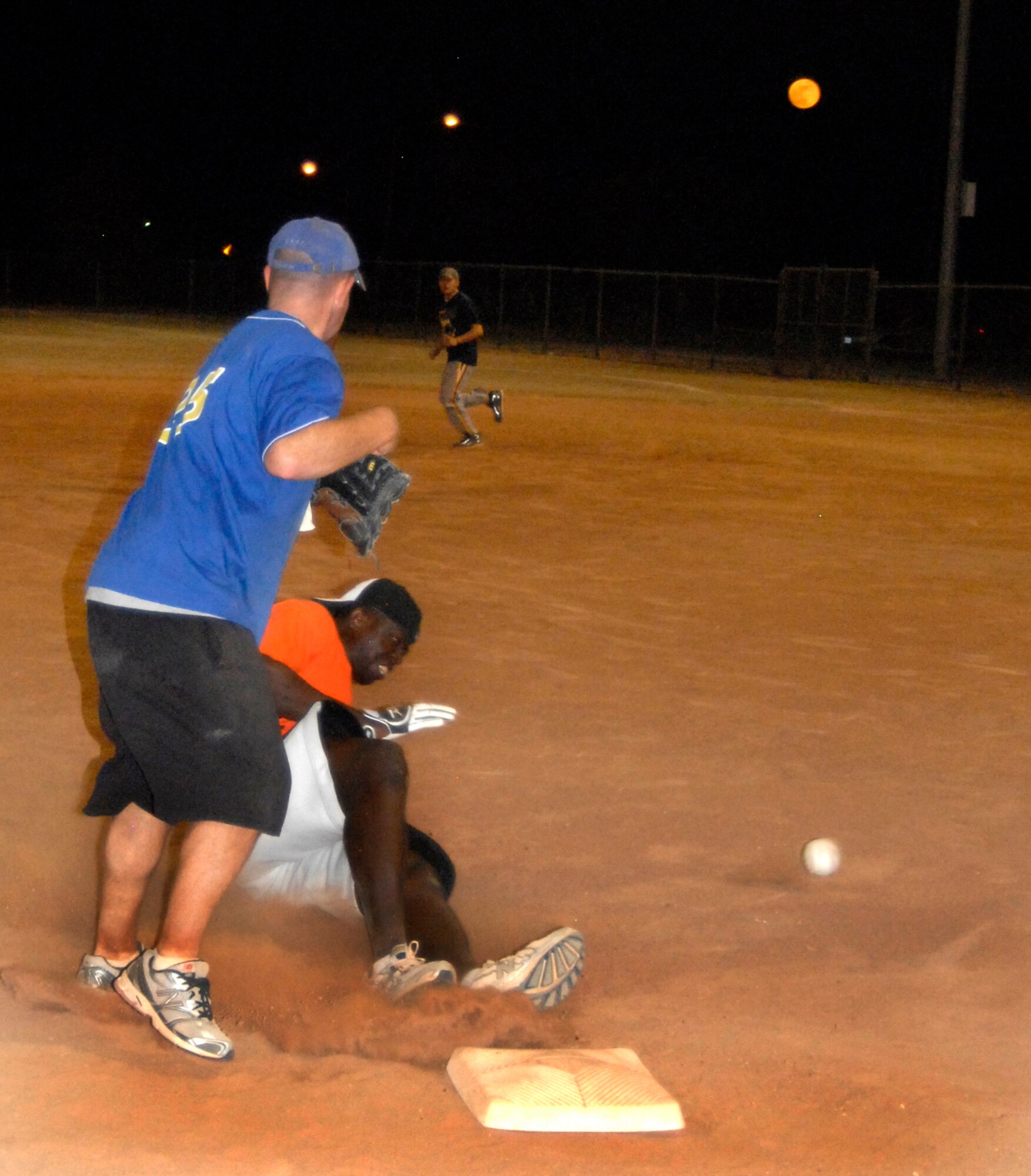 GOODFELLOW AIR FORCE BASE, Texas -- Tigers' James Nicholson slides safely to third thanks to a bad pass to 1st Responders' third baseman Jeff Bockhorn.  After playing a three-game championship series June 15, the 17th Security Forces Squadron 1st Responders defeated the 17th Training Support Squadron Tigers two games to one, taking home this year's Championship title.  (U.S. Air Force photo/Connie Hempel)