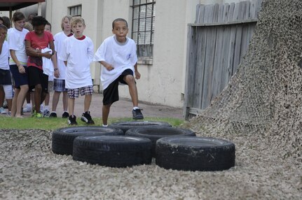 Randolph children take turns running through the tires on the obstacle course during Operation Families Learning about Global Support on June 10. (US Air Force photo/A1C Precious Yett)