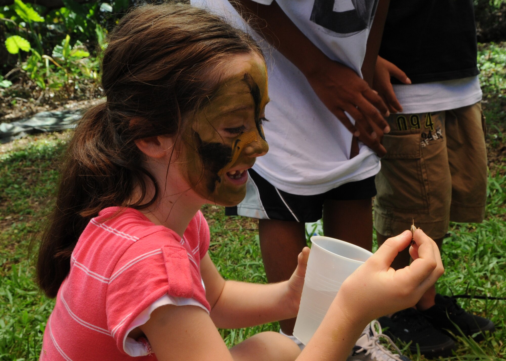 KADENA AIR BASE, Japan -- Holly Markowski smiles just before eating a cricket during a Survival, Evasion, Resistance and Escape orientation here June17 during the 353rd Special Operations Group Family Appreciation Day. Families from the 353rd SOG were treated to orientation flights, equipment displays and a brief Survival, Evasion, Resistance and Escape orientation during the event. (U.S. Air Force photo by Tech. Sgt. Aaron Cram)