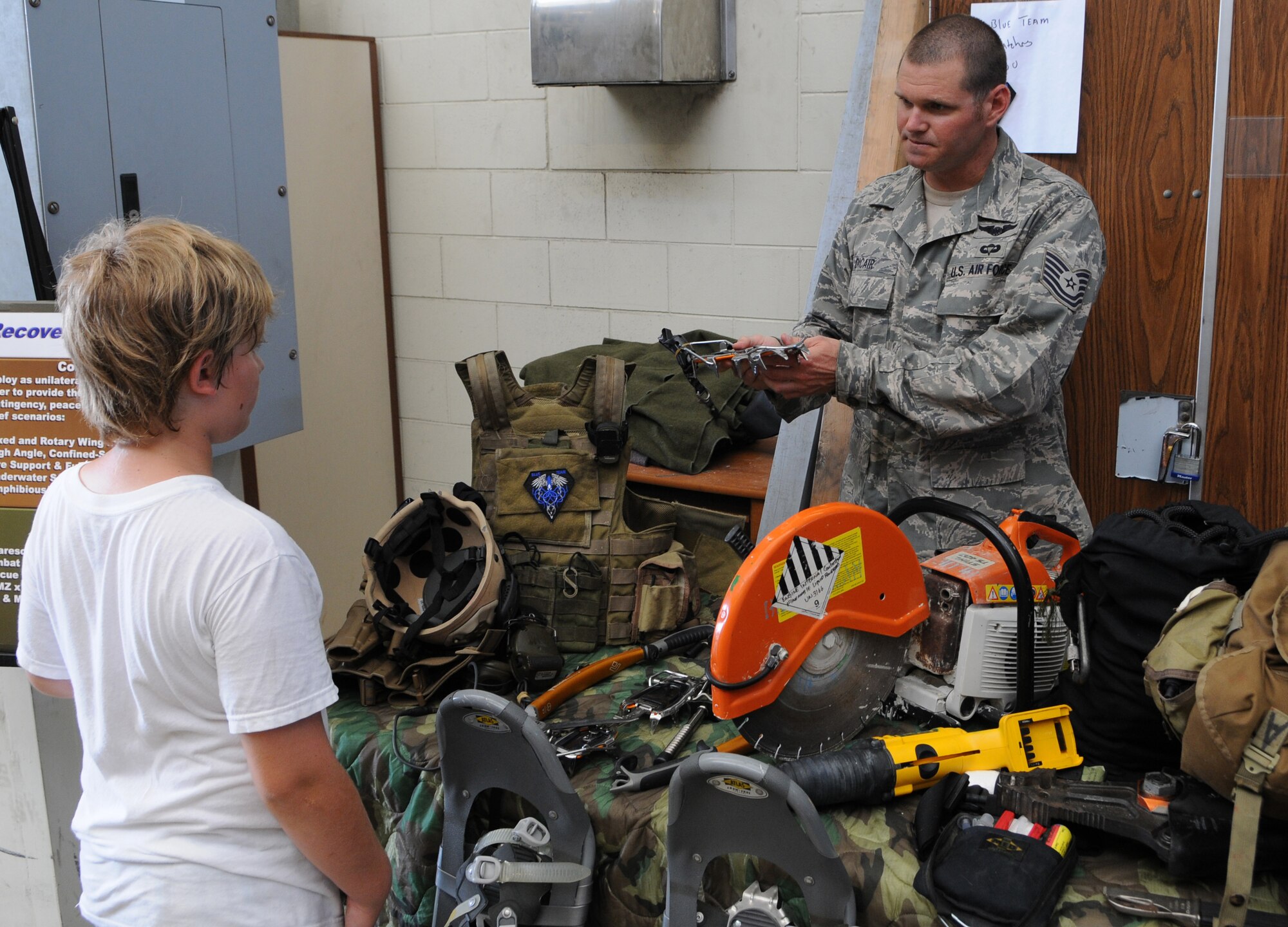 KADENA AIR BASE, Japan -- Tech. Sgt. Justin Dicair, a pararescueman with the 320th Special Tactics Squadron, shows some of his gear here June17 during the 353rd Special Operations Group Family Appreciation Day. Families from the 353rd SOG were treated to orientation flights, equipment displays and a brief Survival, Evasion, Resistance and Escape orientation during the event. (U.S. Air Force photo by Tech. Sgt. Aaron Cram)
