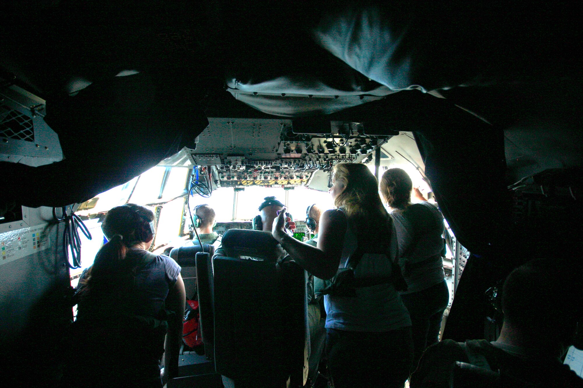 KADENA AIR BASE, Japan -- Spouses look out of the cockpit of a MC-130H Combat Talon II here June17 during a orientation flight as part of the 353rd Special Operations Group Family Appreciation Day. Families from the 353rd SOG were treated to orientation flights, equipment displays and a brief Survival, Evasion, Resistance and Escape orientation during the event. (U.S. Air Force photo by Staff Sgt. Albert Noffsinger)