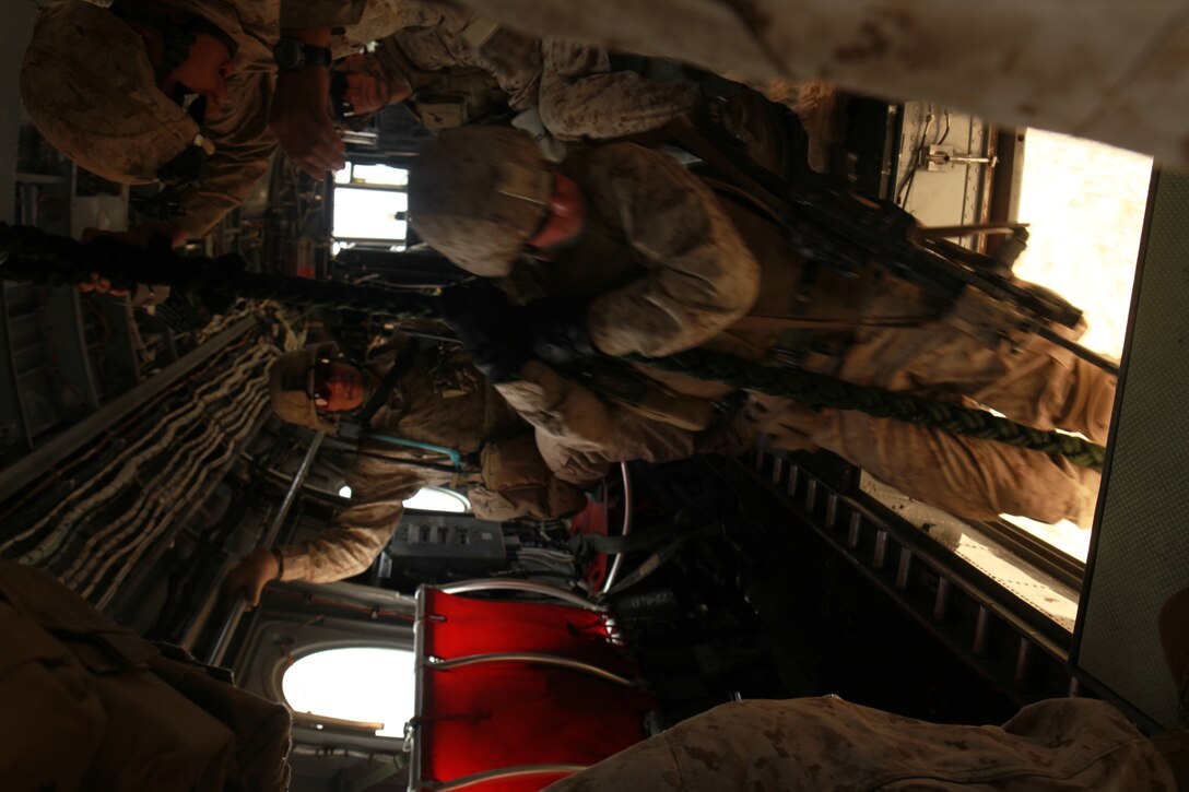 A Marine with the 11th Marine Expeditionary Unit's maritime raid force fast ropes from a CH-46E Sea Knight during an MRF training course June 17. Fast roping is a technique used to quickly descend into a target site without landing the aircraft.::r::::n::::r::::n::::r::::n::
