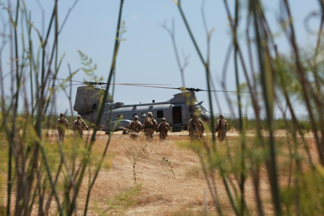 Marines with the 11th Marine Expeditionary Unit's maritime raid force move to a CH-46E Sea Knight to practice fast roping during an MRF training course June 17. Fast roping is a technique used to quickly descend into a target site without landing the aircraft.::r::::n::::r::::n::::r::::n::