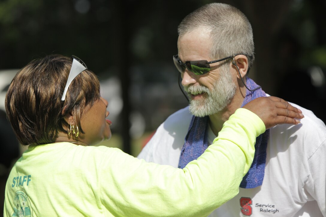 Bernadine Crosby, the MCCS special events coordinator for Cherry Point, congratulates Michael Reed, a psychologist from nearby New Bern, N.C., after Reed finished first in the 51-60 age group in the station’s annual MCCS Mountain Bike Challenge June 18. “Nobody puts on a better affair than the Marines do,” said Reed. “Cherry Point has a great outreach to the community.”