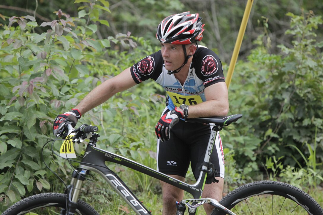 John J. Lynch, operations officer for MARSOC, Marine Corps Base Camp Lejeune, catches his breath after crossing the finish line first during Cherry Point’s annual MCCS Mountain Bike Challenge at the Piranha Pit trails June 18. Lynch finished the seven-mile, tree winding course in 28 minutes, 14 seconds.