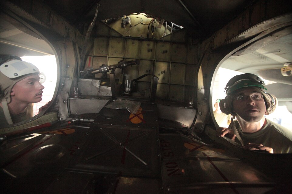 Lance Cpl. Cody Kaiser, left, and Cpl. Jesse Rivera, both Marine Attack Squadron 513 airframe mechanics, inspect one of the squadron’s AV-8B Harriers after putting its wing set back on in the squadron hangar at Kandahar Airfield, Afghanistan, June 18.