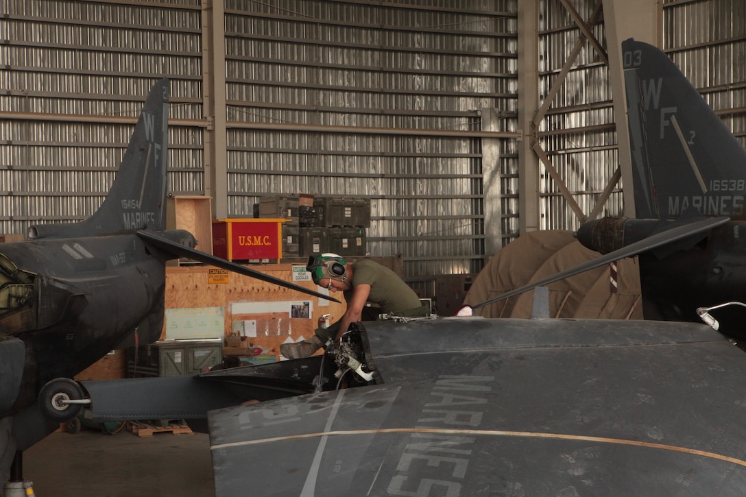 Cpl. Michael Merriman, a Marine Attack Squadron 513 airframes mechanic and Mendota, Ill., native, hooks up the wing sling so a set of wing’s can be put back on one of the squadron’s AV-8B Harriers in the squadron hangar at Kandahar Airfield, Afghanistan, June 18.