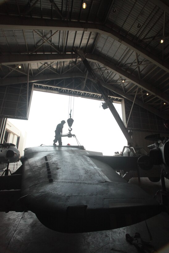 Lance Cpl. Cody Kaiser, a Marine Attack Squadron 513 airframes mechanic and Warsaw, Ind., native, hooks the wings of an AV-8B Harrier to a crane in the squadron hangar at Kandahar Airfield, Afghanistan, June 18.
