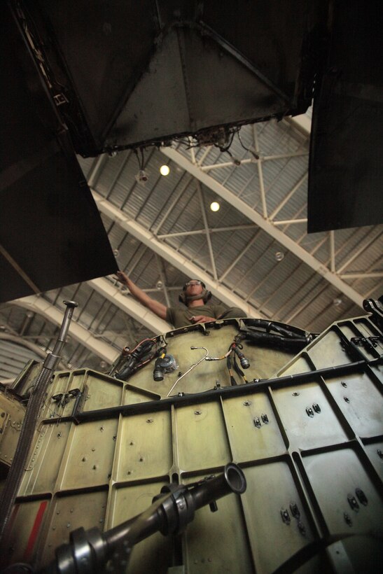 Cpl. Michael Merriman, a Marine Attack Squadron 513 airframes mechanic and Mendota, Ill., native, reaches for the wing set of one of the squadron’s AV-8B Harriers in the squadron hangar at Kandahar Airfield, Afghanistan, June 18.
