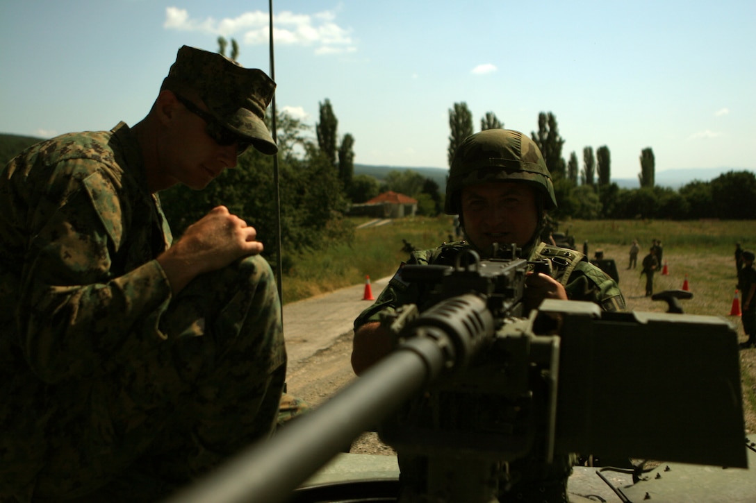 During a period-of-instruction for convoy operations, Cpl. Nicholas Porter, rifleman and Amarillo, Texas, native, Black Sea Rotational Force 11, advises a Serbian soldier on the responsibilities of a “gunner” while doing Improvised-Explosive Device (IED) awareness training. BSRF-11 will be working with the Serbian and Bulgarian troops in Novo Selo training area in counterinsurgency and peacekeeping operations to advise and build the military capacities of these nations.::r::::n::
