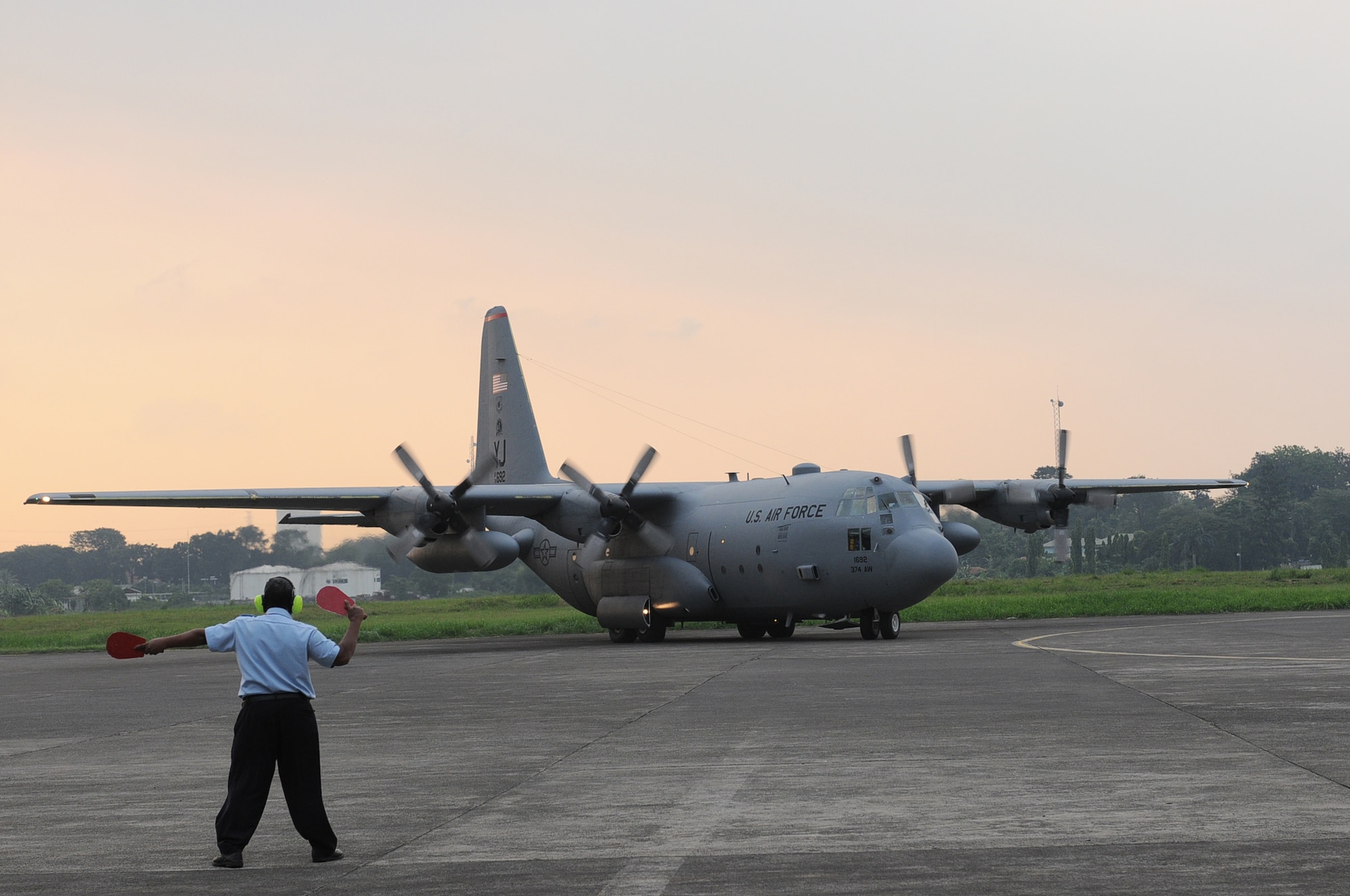 HALIM AIR BASE, Indonesia -- An Indonesian airfield manager marshals a C-130 Hercules from the 36th Airlift Squadron at Yokota Air Base, Japan, to its parking space at Halim Air Base, Indonesia, June 18, 2011. The C-130 will participate in Exercise Cope West 11. During the exercise, Airmen from Indonesia and the U.S. will work side-by-side, both on the ground and in the air, to hone their skills for possible future real-world contingency operations. (U.S. Air Force photo/Capt. Raymond Geoffroy)