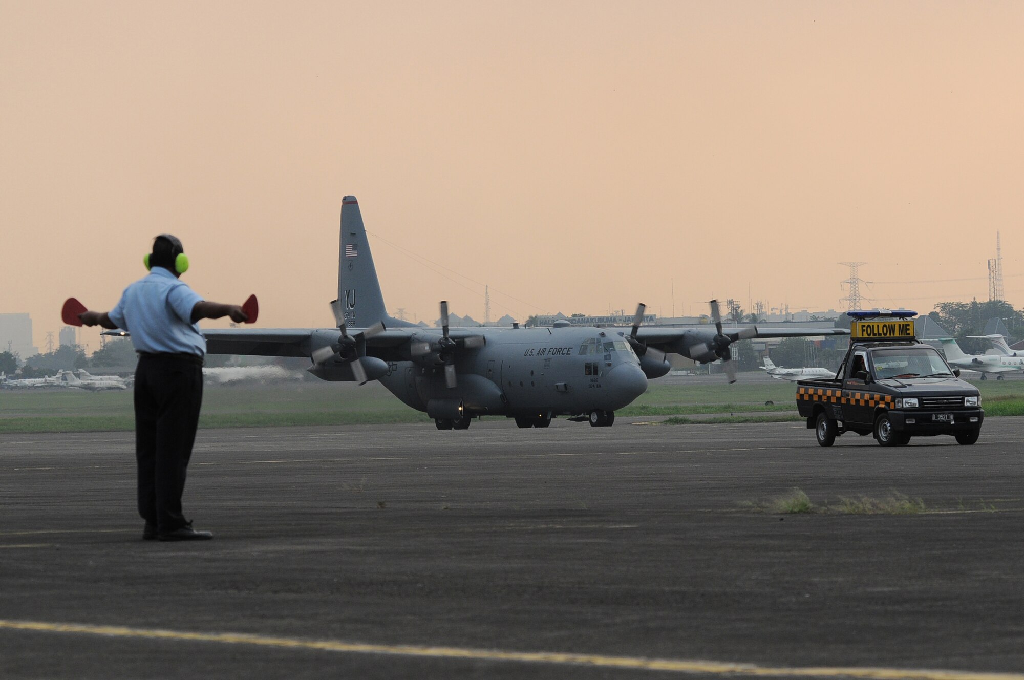 HALIM AIR BASE, Indonesia -- An Indonesian airfield manager marshals a C-130 Hercules from the 36th Airlift Squadron at Yokota Air Base, Japan, to its parking space at Halim Air Base, Indonesia, June 18, 2011. The C-130 will participate in Exercise Cope West 11. During the exercise, Airmen from Indonesia and the U.S. will work side-by-side, both on the ground and in the air, to hone their skills for possible future real-world contingency operations. (U.S. Air Force photo/Capt. Raymond Geoffroy)