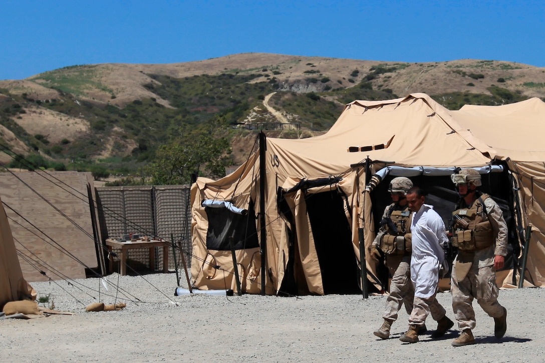 Marines with the 11th Marine Expeditionary Unit apprehend a role-player at a simulated evacuation site here June 18. The exercise prepared 11th Marine Expeditionary Unit members to protect and safely evacuate noncombatants in foreign countries, according to 1st Lt. Ryan D. Betters, Combat Logistics Battalion 11, which provides the unit with logistics and services. Betters, who oversaw the execution of the exercise, serves as the battalion's landing support officer. He hails from Batavia, N.Y.