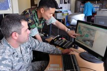 KUNSAN AIR BASE, Republic of Korea -- 1st Lt. Aaron Leroy, 8th Operation Support Squadron wing weather officer, and Maj. Dae Suk Tak, 38th Mission Support Squadron flight commander, collaborate during a sea fog event here June 16. The 10 Airmen assigned to Kunsan's Weather Flight keep the section running 24 hours a day, seven days a week, and work hand-in-hand with Republic of Korea Air Force weather personnel. (U.S. Air Force photo/Senior Airman Brittany Y. Bateman)