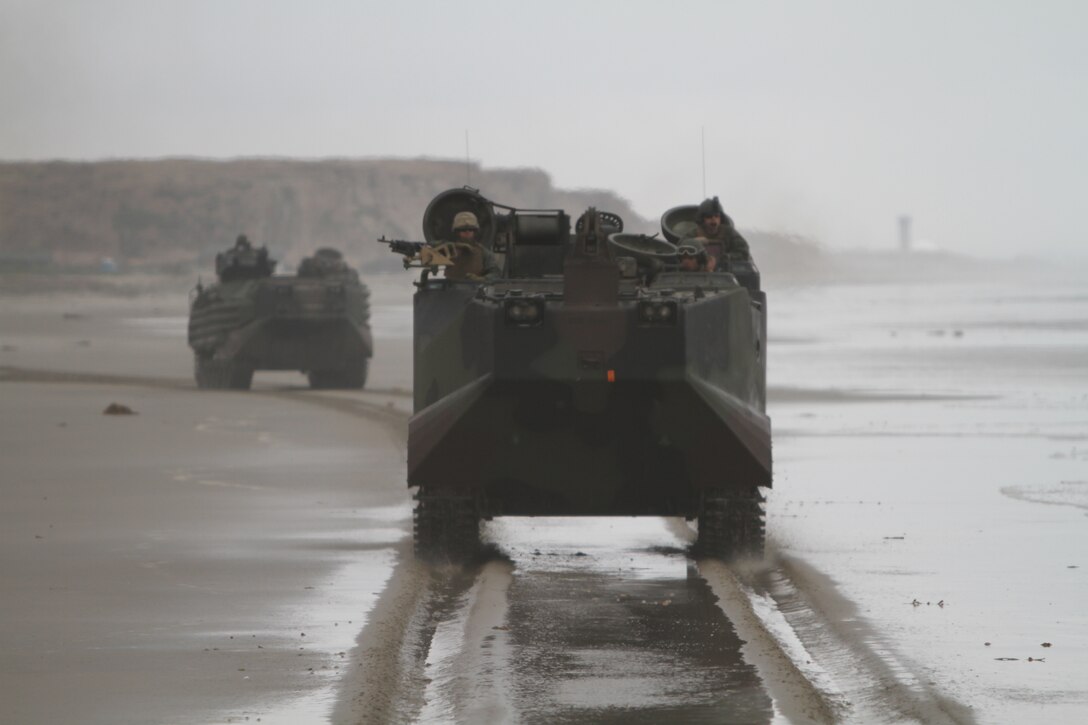Amphibious assault vehicles drive along Red Beach here en route to an urban training town June 19 during the 11th Marine Expeditionary Unit's two-week field exercise. The vehicles carried Marines and sailors of Battalion Landing Team 3/1, the ground-combat element for the unit.