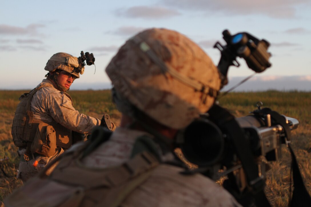 Cpl. William G. Stickney watches a Marine simulate launching a rocket during night raid rehearsals here June 19. Stickney, a 22-year-old Roanoke, Va., native, serves as a machine gun team leader with Company L, one of three rifle companies in Battalion Landing Team 3/1, the ground-combat element for the 11th Marine Expeditionary Unit. The unit recently began its first full-scale exercise since becoming a complete Marine air-ground task force in May.