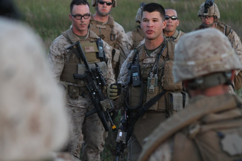 Platoon commander 2nd Lt. John P. Krudy debriefs Marines and sailors after night raid rehearsals here June 19. Krudy, a 24-year-old Vienna, Mich., native, serves with Company L, one of three rifles companies in Battalion Landing Team 3/1, the ground-combat element for the 11th Marine Expeditionary Unit. The unit recently began its first full-scale exercise since becoming a complete Marine air-ground task force in May.