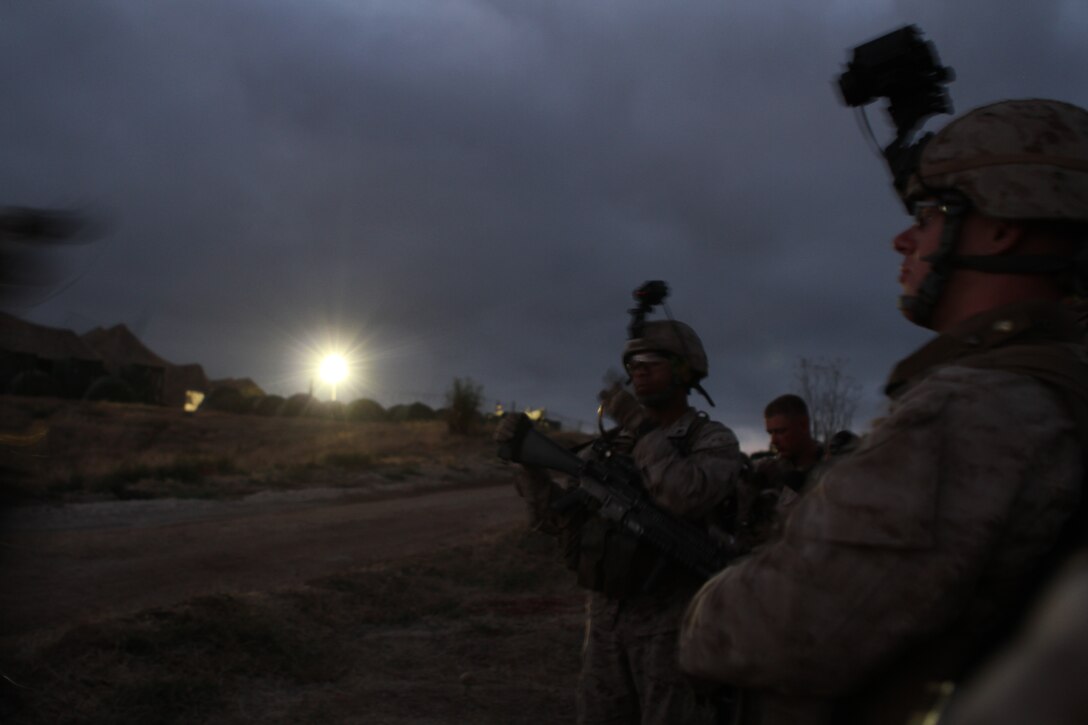 Company L Marines wait for nightfall before conducting a training raid here June 19. The rifle company is one of three in Battalion Landing Team 3/1, the ground-combat element for the 11th Marine Expeditionary Unit. The unit recently began its first full-scale exercise since becoming a complete Marine air-ground task force in May.