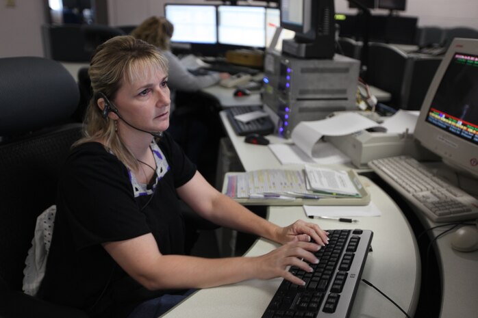 Angela Wade, a 911 dispatcher at the Camp Lejeune 911 Emergency Consolidated Communications Center, takes calls and monitors five different screens at the center, June 20.  The center is responsible for 911 calls from Marine Corps Base Camp Lejeune, Marine Corps Air Station New River and the satellite facilities.