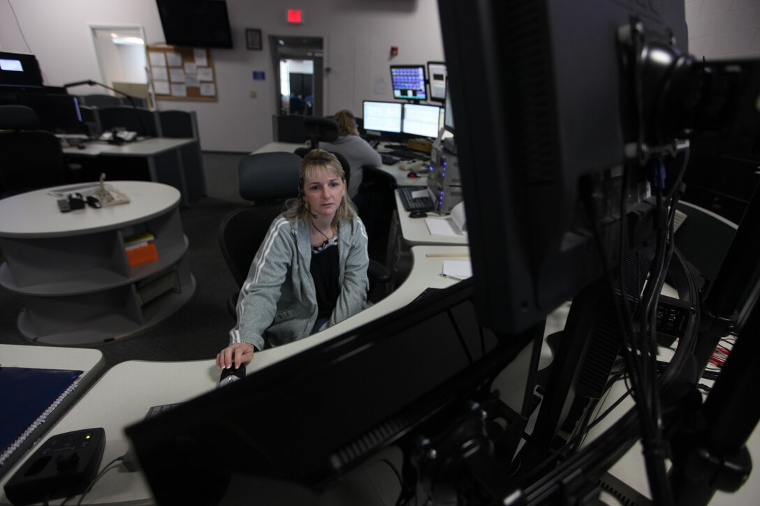 Angela Wade, a 911 dispatcher at the Camp Lejeune 911 Emergency Consolidated Communications Center, takes calls and monitors five different screens at the center, June 20.  “It can be stressful,” she said of her job.  “You have to be able to multitask.”  The center is responsible for 911 calls from Marine Corps Base Camp Lejeune, Marine Corps Air Station New River and the satellite facilities.