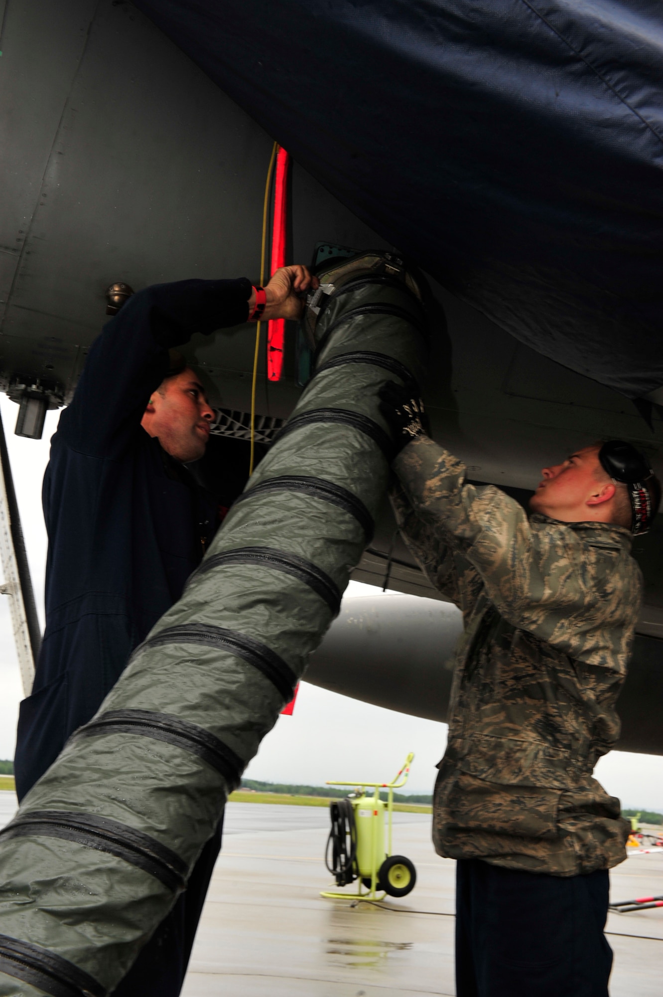 (From right to left) U.S. Air Force Senior Airman Joshua Brown, an electrical/environmental technician  and Airman 1st Class Cody Weller, a crew chief, both with the 18th Aircraft Maintenance Squadron, Kadena Air Base, Japan, tighten an air hose to an adaptor unit on an F-15 Eagle during the Northern Edge Premier Joint Training Exercise at Eielson Air Force Base, Alaska, June 20.  Northern Edge is Alaska?s largest military training exercise. (U.S. Air Force photo/ Staff Sgt. Lakisha A. Croley)