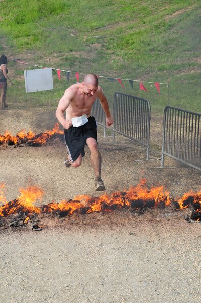 MECHANICSVILLE, Md. -- Tech. Sgt. Jonathan Propst, 459th Maintenance Squadron, leaps over a row of flames during the three-mile Warrior Dash here May 21. The Warrior Dash is a nationwide extreme race that pits thousands of racers against military-style obstacles like wooden wall climbs and staggered logs. The dash also has unique features like a mud-covered slide and rusted automobile wreckage to traverse. Airmen from the 459th Air Refueling Wing participated in this year's race along with over 8,700 competitors during the Saturday race. (Submitted photo)