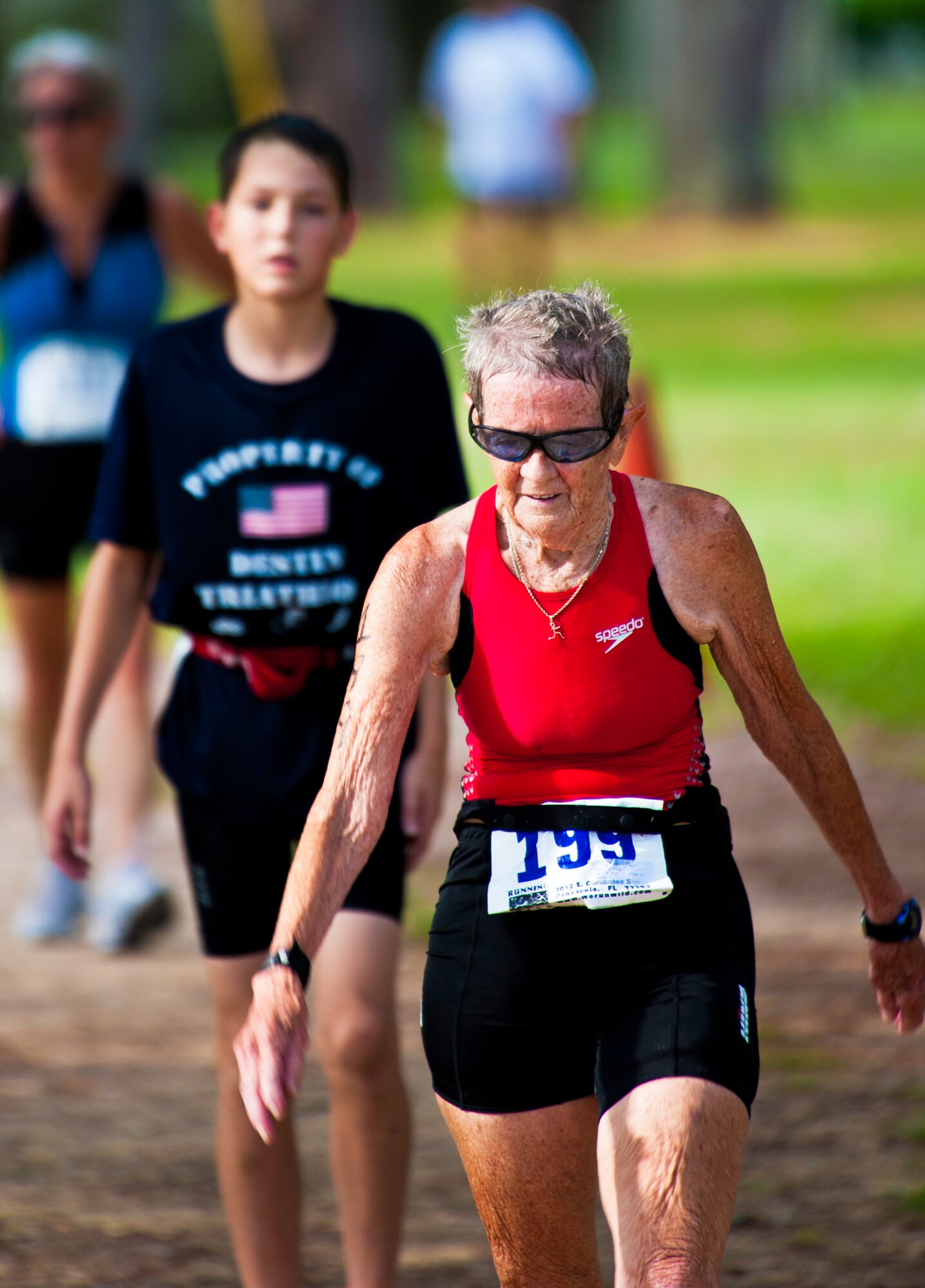 Billie Madero, age 80, walks the last mile of this year’s “My First Tri” triathlon at Eglin Air Force Base Fla., June 18.  Almost 350 people of all ages “tried” at the 12th annual event.  The triathlon consists of a 200-meter swim, eight-mile bike ride, then a 2.5-mile run.  Madero, the oldest person to compete in the event, finished in one hour and 24 minutes.   (U.S. Air Force photo/Samuel King Jr.)