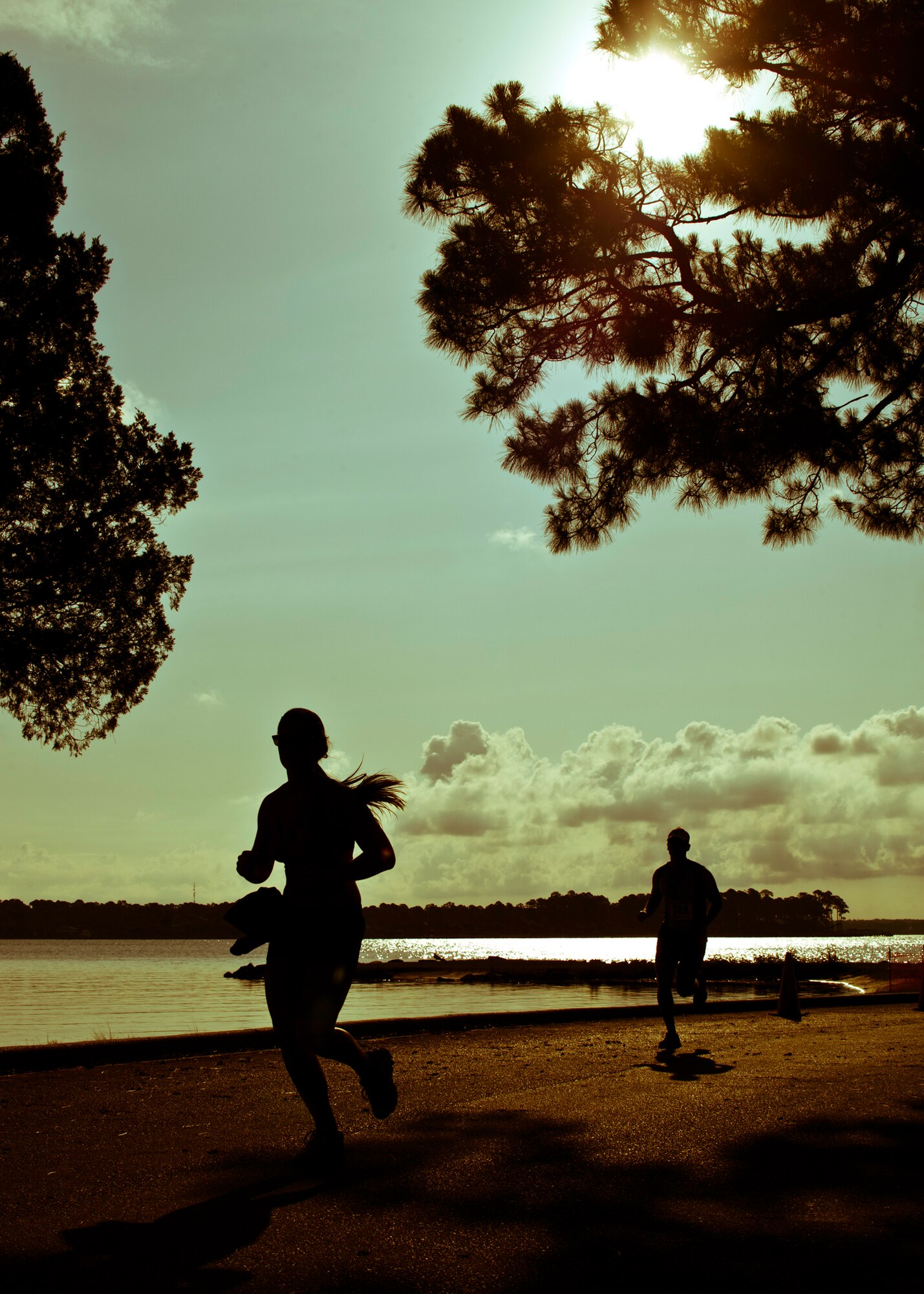 Runners pass the final turn at this year’s “My First Tri” triathlon at Eglin Air Force Base Fla., June 18.  Almost 350 people of all ages “tried” at the 12th annual event.  The triathlon consists of a 200-meter swim, eight-mile bike ride, then a 2.5-mile run.  (U.S. Air Force photo/Samuel King Jr.)