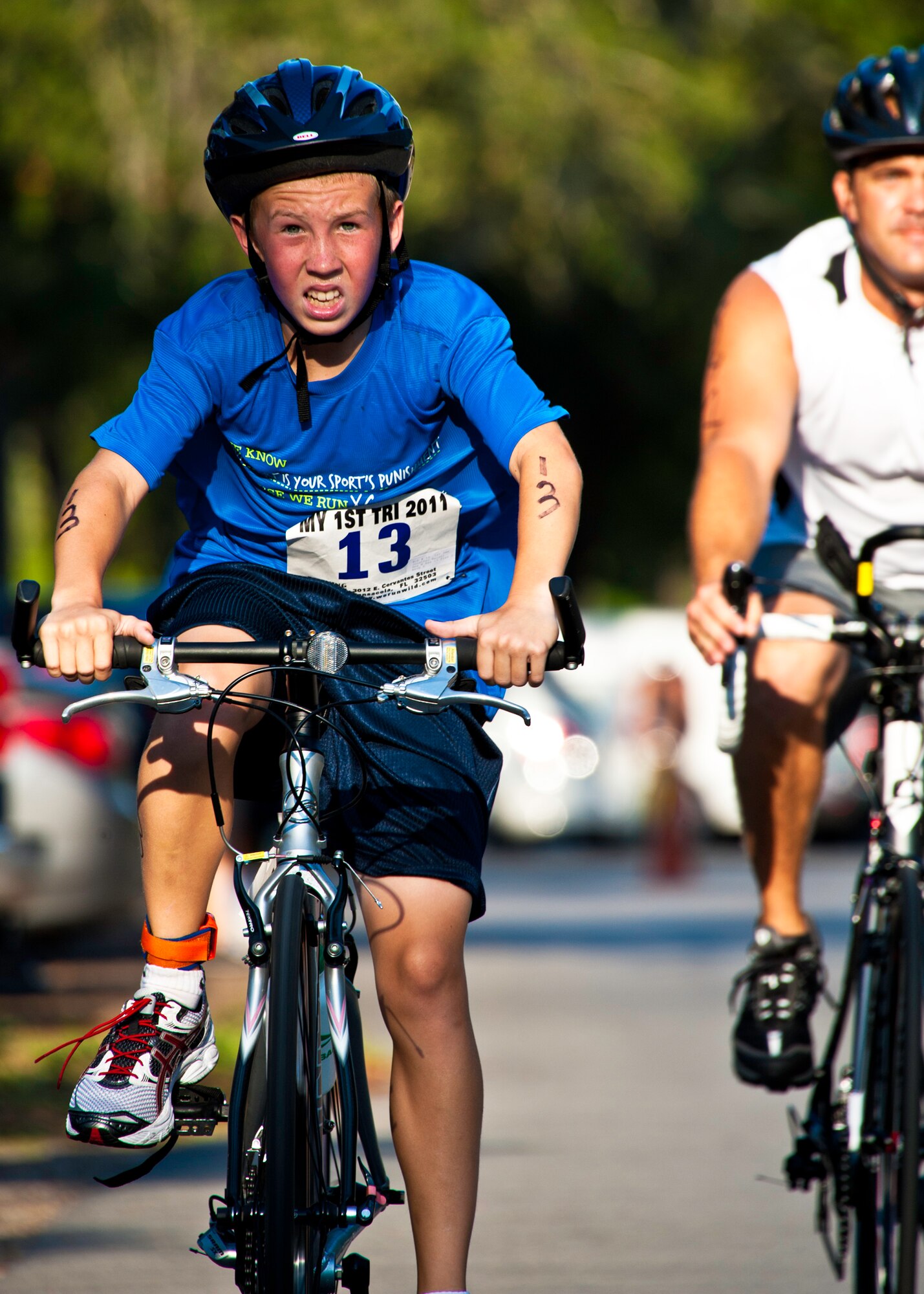 Jonathan Balent, age 13, pedals to the finish of the bike ride at this year’s “My First Tri” triathlon at Eglin Air Force Base Fla., June 18.  Almost 350 people of all ages “tried” at the 12th annual event.  The triathlon consists of a 200-meter swim, eight-mile bike ride, then a 2.5-mile run.  (U.S. Air Force photo/Samuel King Jr.)
