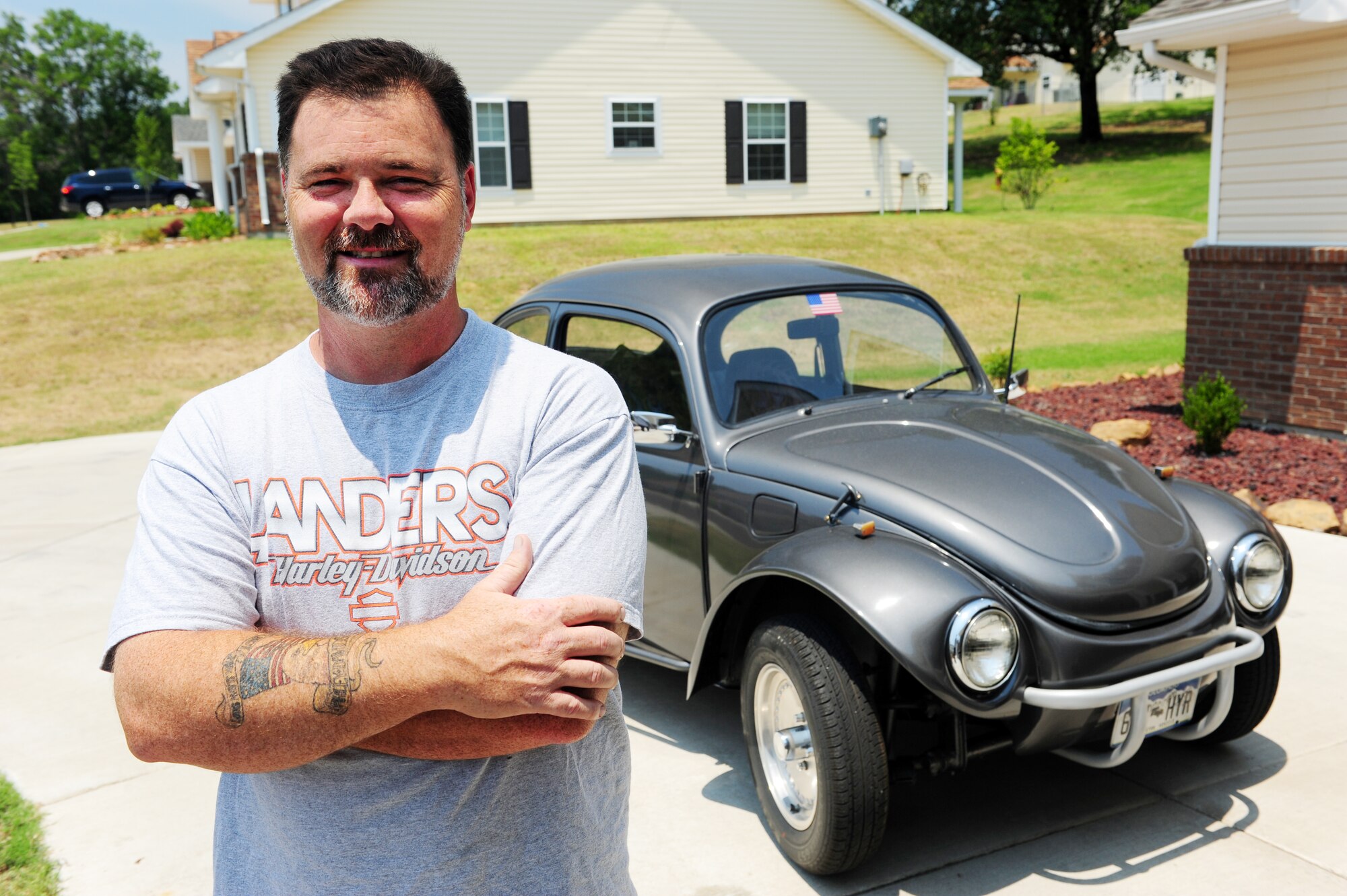 Jerry Lee "Buzz" Horne Jr., spouse of Lt. Col. Debbie Horne, 19th Force Support Squadron commander, stands in front of his 1968 Volkswagon Beetle "the Buzz mobile" June 14, 2011. A jack of all trades, his experience as a military spouse/father/retired NCO/fighter crew chief/mechanic/carpenter/electrician/plumber/teacher/biker/baker/artist/photographer/emcee/roadie and paramedic has helped the Little Rock community. (U.S. Air Force photo by Staff Sgt. Jim Araos)