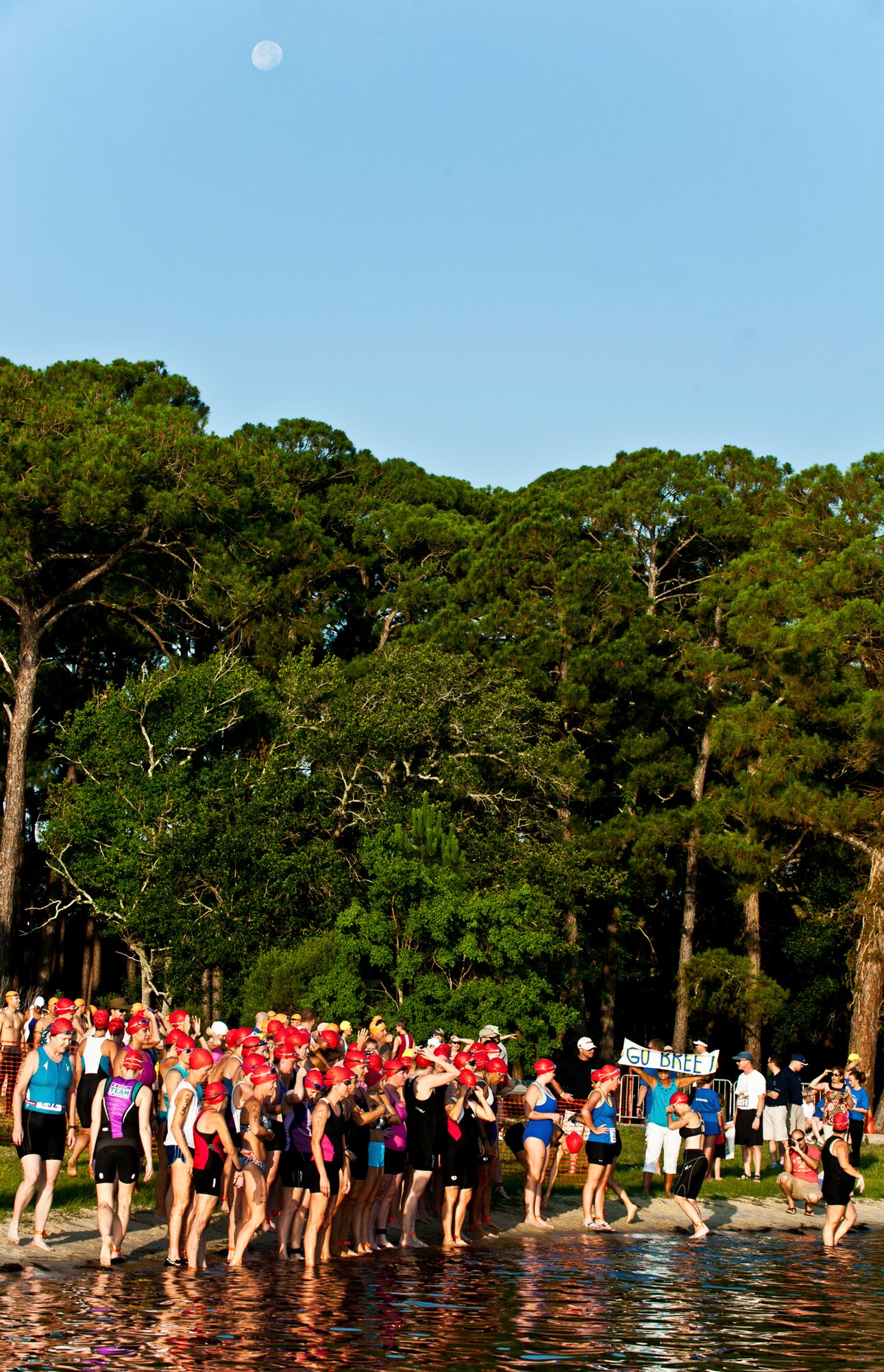 The moon recedes as the day and race begins at Eglin’s Post’l Point June 18.  Almost 350 people of all ages “tried” at the 12th Annual “My First Tri” triathlon event.  The event consists of a 200-meter swim, eight-mile bike ride, then a 2.5-mile run.  David Shearon finished with the best overall time - 39 minutes 24 seconds.  Wendy Ewing had the best time for females with 47 minutes 39 seconds. (U.S. Air Force photo/Samuel King Jr.)