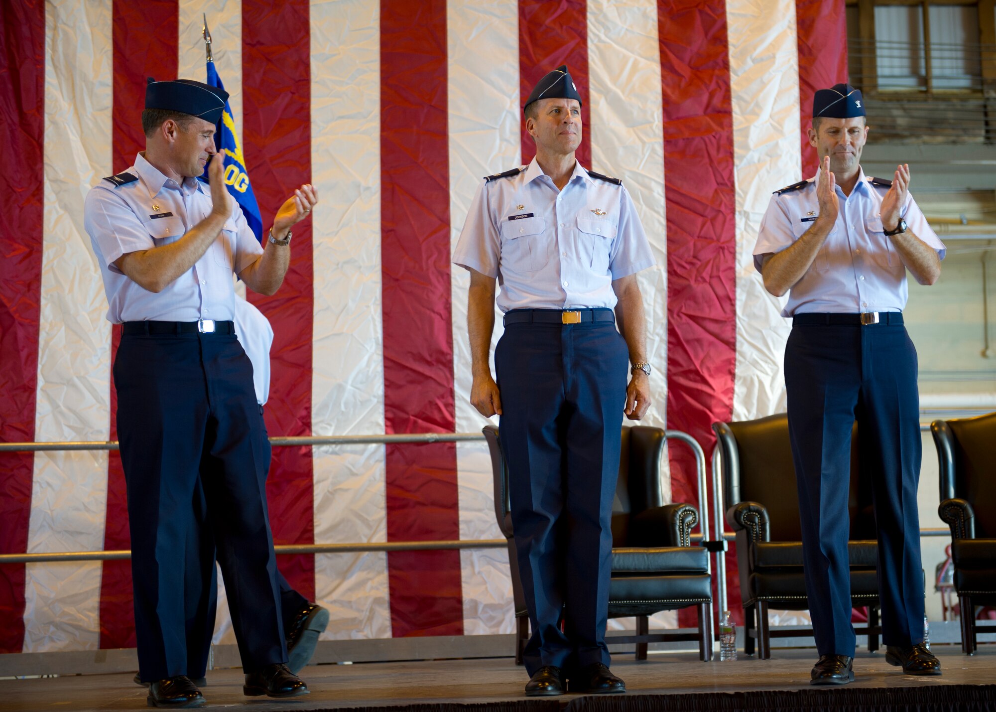 HOLLOMAN AIR FORCE BASE, N.M.-- Lt. Col. Kenneth Johnson, 49th Operations Group commander, receives applause from Col. David Krumm, 49th Wing commander and Col. Kevin Huyck, former 49th OG commander, during the 49th OG change of command ceremony, June 17, 2011 in Hangar 301. Colonel Johnson served as the director of staff for the 432nd Wing at Creech Air Force Base before taking command of the 49th OG. (U.S. Air Force photo by Senior Airman John D. Strong II/Released)