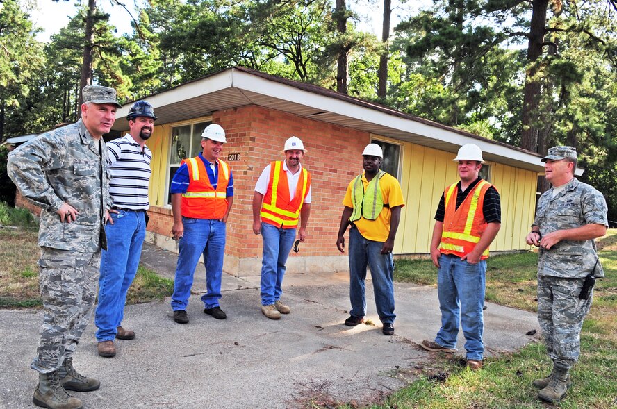 Col. Tim Fay (far left), 2nd Bomb Wing commander and Col. Scott Hoover (far right), 2nd Mission Support Group commander, discuss bulldozer operation with local contractors prior to demolishing the first house in the Capehart Housing Area on the East Reservation of Barksdale Air Force Base, La., June 20. The homes in the Capehart community are being demolished and the area returned to nature; Colonel Fay was invited to help demolish the first of the homes, the rest will be torn-down over the next few months.  (U.S. Air Force photo/Senior Airman Joanna M. Kresge)