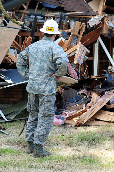 Col. Tim Fay, 2nd Bomb Wing commander, surveys his work outside a demolished home in the Capehart Housing Area located on Barksdale Air Force Base, La., June 20. The homes in the Capehart community are being demolished and the area returned to nature; Colonel Fay was invited to help demolish the first of the homes, the rest will be torn-down over the next few months. (U.S. Air Force photo/Senior Airman Joanna M. Kresge)