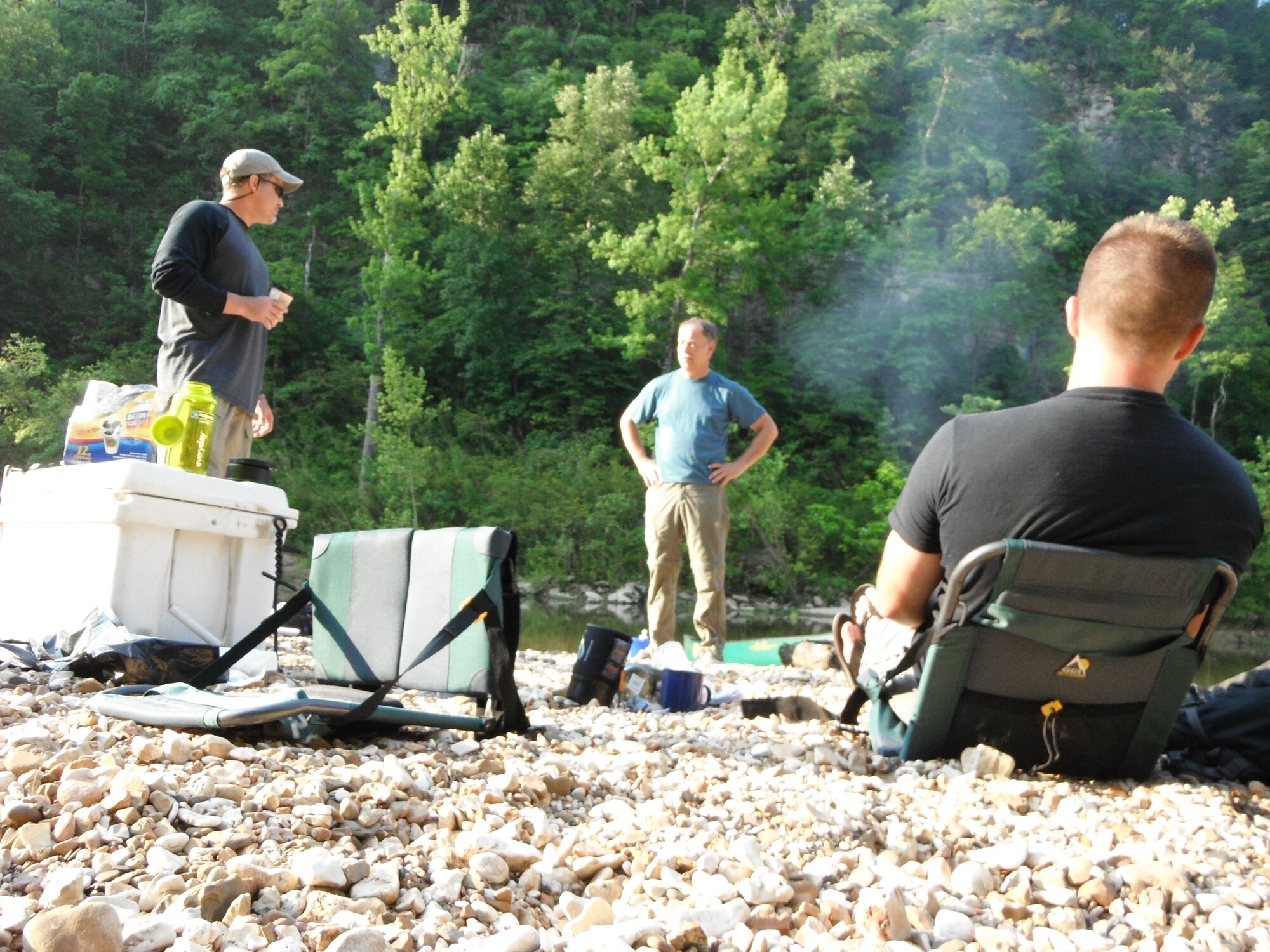 On one of the many shifting shoals along the picturesque Buffalo National River in Arkansas, an enthusiastic group discovered the perfect  place for basking in early morning sunlight after breakfast on an Outdoor Recreation-sponsored trip June 10-11. Jeff Gerlitz, ODR programs coordinator, John Cordon, volunteer trip leader, and Staff Sgt. Marcus Magnant, 552nd Air Control Wing, Communications Squadron, not only enjoy the great outdoors and opportunities ODR trips inspire, but always find camaraderie while perfecting outdoor skills. Everyone in the eight member group had differing levels of paddling experience, all in good physical condition and enjoyed the challenges of paddling more than 41 miles in just under two days on the water. (Air Force photo by Brion Ockenfels)