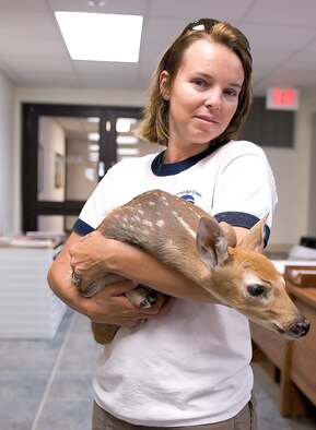 Melody Henderson, bird/wildlife aircraft strike hazard ecologist and wildlife manager, holds a fawn she rescued June 9, 2011, at Dover Air Force Base, Del.’s, flightline. Mrs. Henderson is part of an effort by the Air Force to minimize the amount of bird strikes. (U.S. Air Force Photo/Steve Kotecki) 