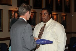 Chester Ellis Jr., receives U.S. flag from Congressman Robert Wittman, U.S. Representative for Virginia’s 1st congressional district, during a flag folding ceremony at Langley Air Force Base, Va., June 17, 2011. The flag was presented to him after the original was destroyed in a tornado in Arkansas in honor of Chester Ellis Sr., who served two Army tours in Korea. (U.S. Air Force photo by Airman 1st Class Racheal Watson/Released)