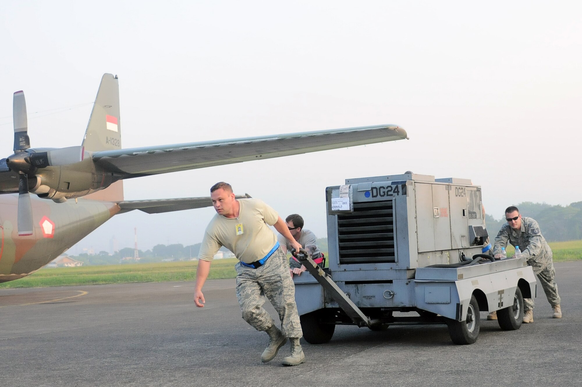 HALIM AIR BASE, Indonesia -- Master Sgt. Greg Lilly, a production supervisor with the 374th Aircraft Maintenance Squadron at Yokota Air Base, Japan, leads fellow maintainers in moving a generator cart in preparation for the first flight mission of Exercise Cope West 11 at Halim Air Base, Indonesia, June 20, 2011. Three Yokota C-130 aircraft and more than 70 Yokota airmen, as well as one Indonesian Air Force C-130 participate in this week-long bilateral field training exercise which is designed to enhance the readiness and combined interoperability between the U.S. and Indonesian Air Forces. (U.S. Air Force photo/Capt. Raymond Geoffroy)