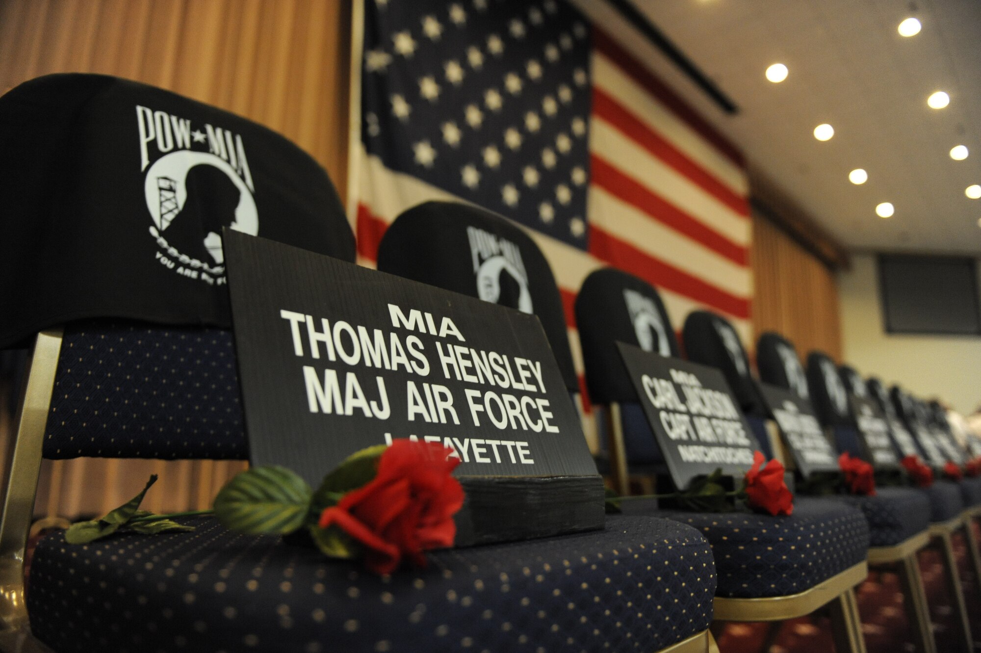 Placards rest on chairs next to red roses during the Prisoner of War/ Missing in Action Purple Heart Luncheon on Barksdale Air Force Base, La., June 17. The placards were placed to remember and honor the military members from the state of Louisiana that are MIA. (U.S. Air Force photo/Airman 1st Class Micaiah Anthony)(RELEASED)