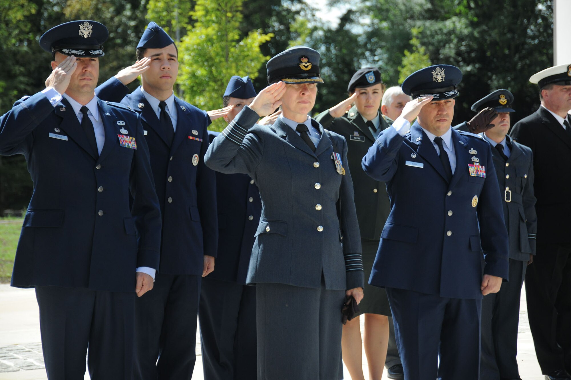 Lt. Col Michael Reiner, Group Commander Bea Wolcott and Col. Brian Kelly salute during the U.K. national anthem during an Armed Forces Day event in Huntingdon June 20.