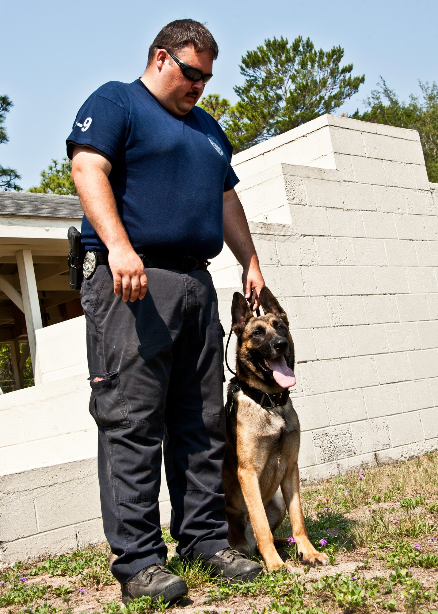 Officer Charles Pettis and Astro, Fort Walton Beach Police Department, take a break from training June 14 at Eglin Air Force Base, Fla.  Officer Pettis and Astro are training with Eglin security forces military working dog handlers to become a certified K-9 team.  They are the second FWBPD K-9 team Eglin trainers have prepared for certification.  (U.S. Air Force photo/Samuel King Jr.)