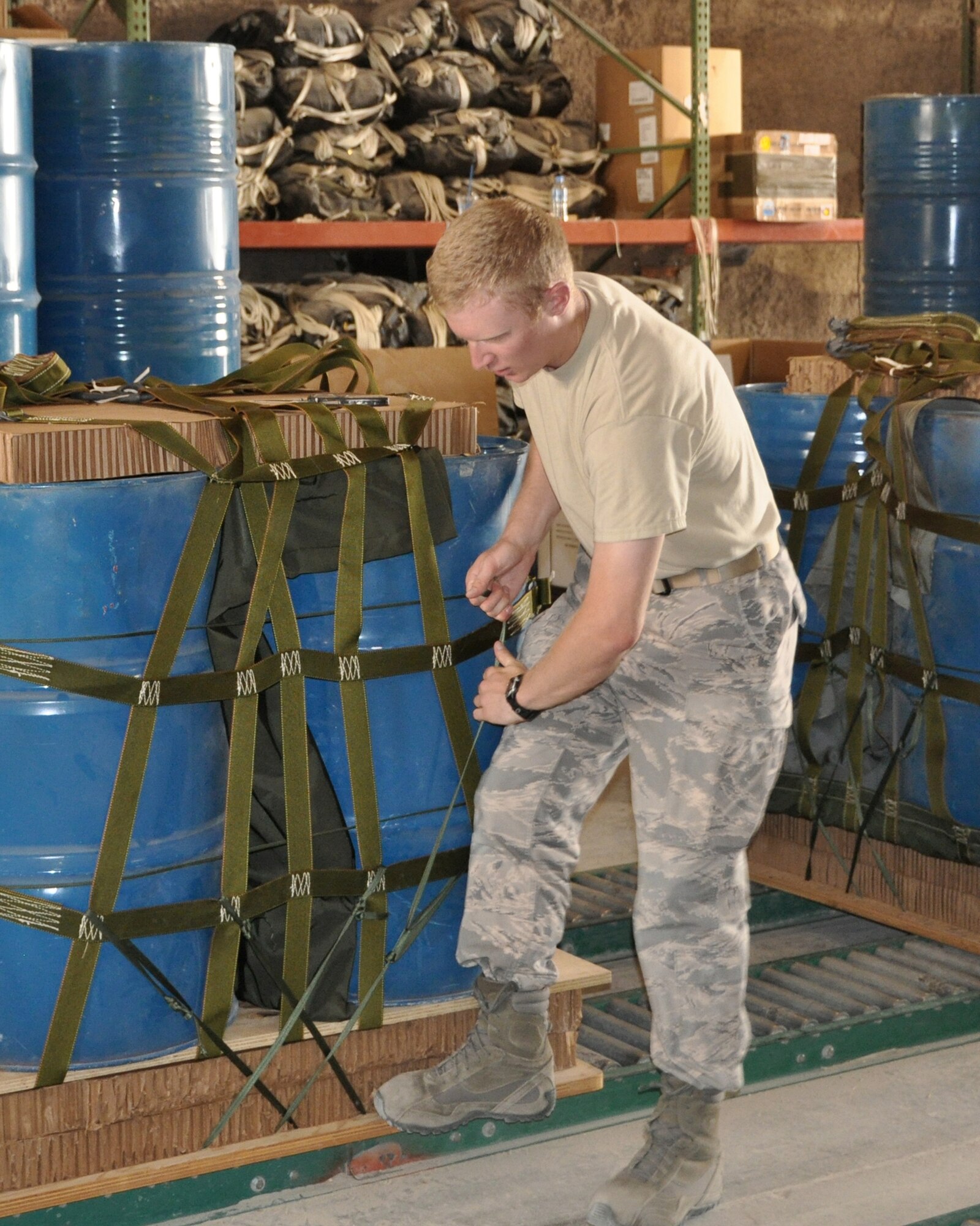U.S. Air Force Academy Cadet 1st Class Jordan Wittman pulls on straps to ensure the cargo bundle is securely fastened to the pallet while working with U.S. Army Riggers June 18, 2011, in Southwest Asia. Cadet Wittman is taking part in "Deployed Ops", a summer program that sends Academy cadets to deployed locations to follow officers in different career fields and to gain an understanding of career responsibilities. (U.S. Air Force photo/Cadet 1st Class Shaina Thompson)
