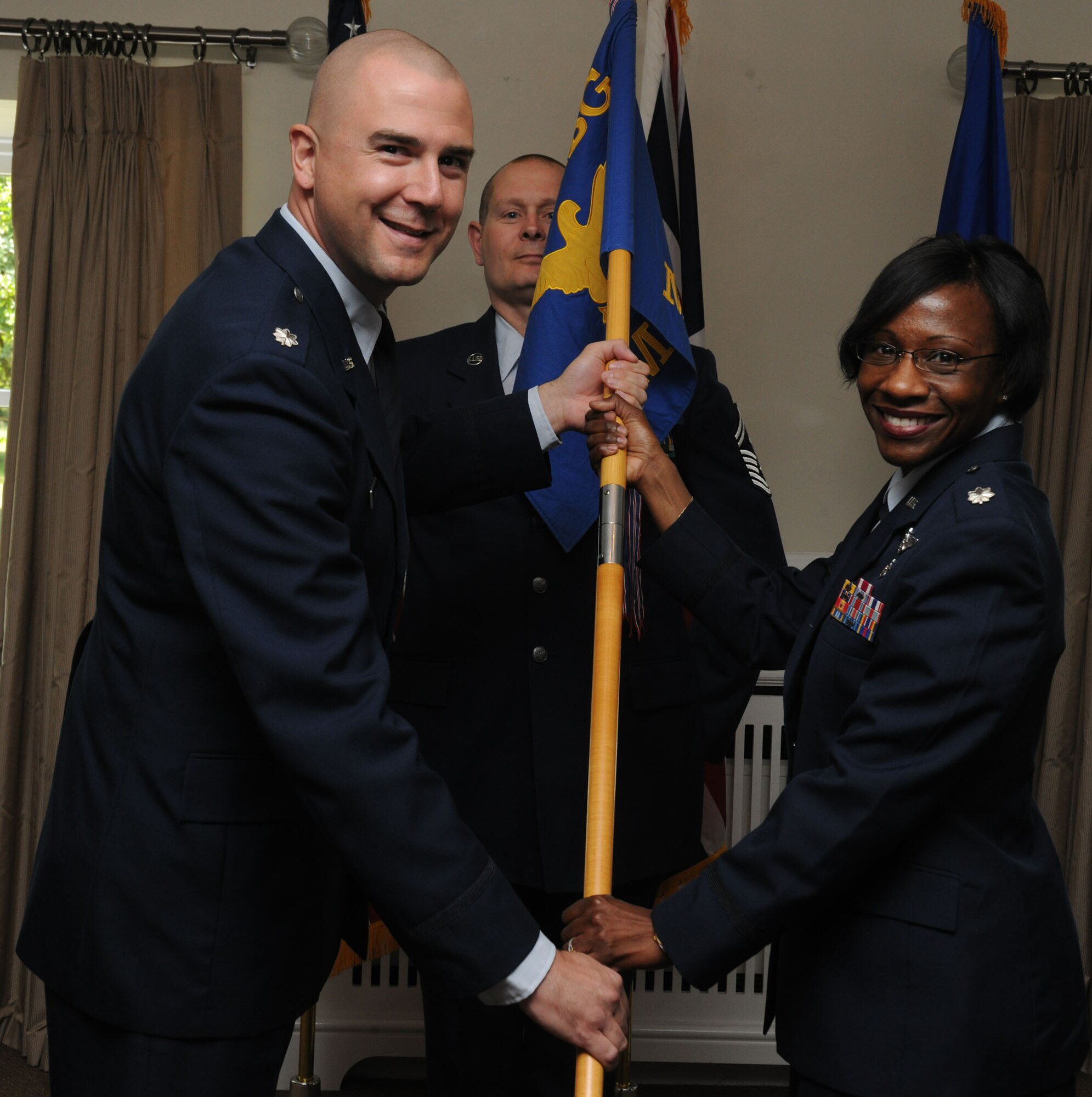 Lt. Col. Michael Reiner presents the 423rd Medical Squadron guidon to Lt. Col. Cherron Galluzzo during a change of command ceremony June 14. Colonel Reiner is the 423rd Air Base Group commander and Col. Galluzzo is the new 423rd MDS commander.