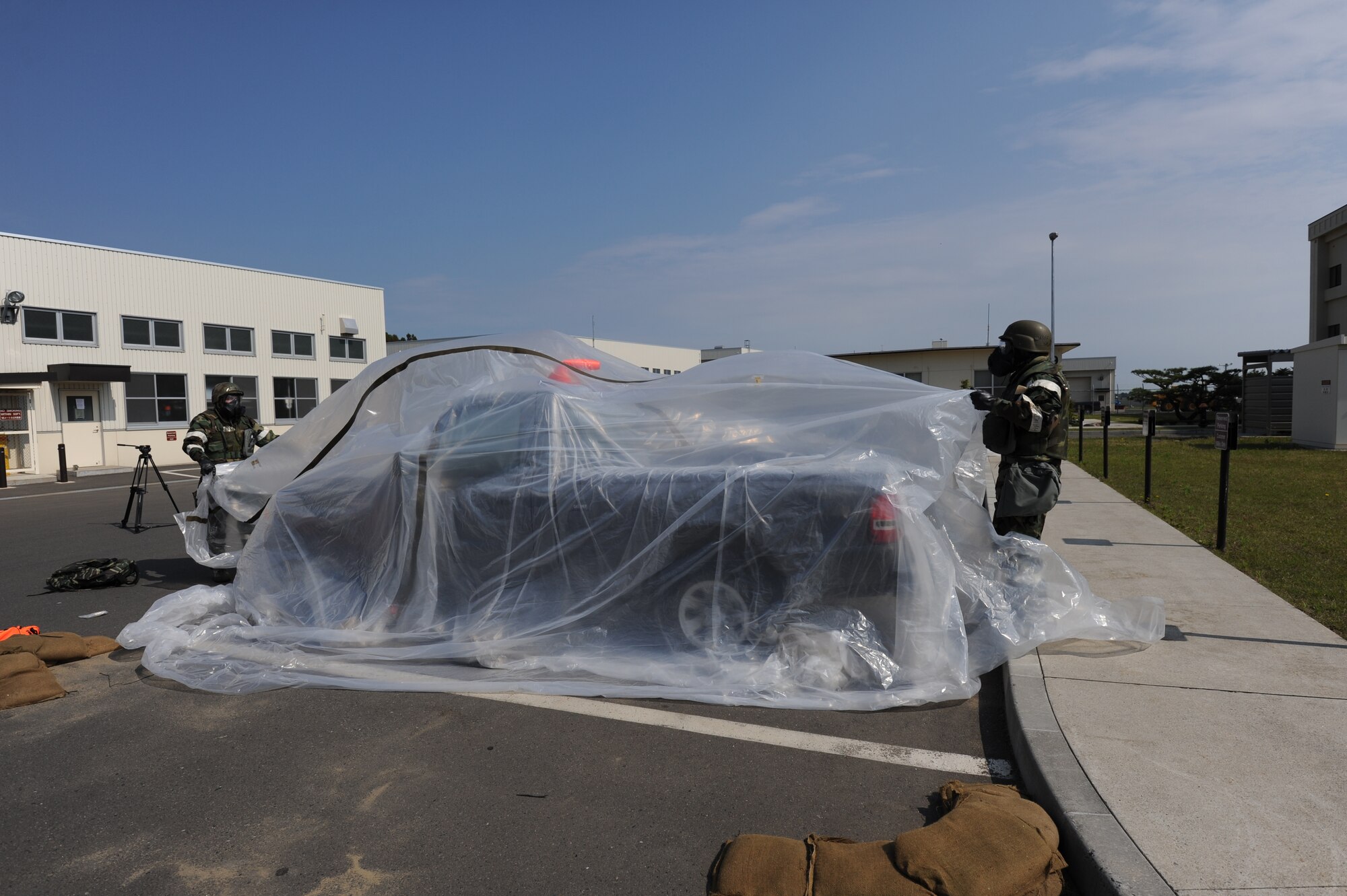 MISAWA AIR BASE, Japan -- Airman 1st Class Eric Jones, 35th Civil Engineer Squadron post attack reconnaissance team member,takes actions to protect a vehicle from potential contamination during a training exercise June 20.  Training on contamination avoidance and control measures help Airmen to survive and operate in chemical, biological, radiological, nuclear and high-yield explosive environments. (U.S. Air Force photo/Staff Sgt. April Quintanilla)