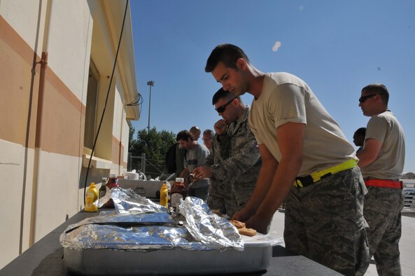 Airman of the 313th Air Expeditionary Wing enjoy a traditional summertime treat of hamburgers, hot dogs, potato salad, and baked beans prepared for them by senior enlisted leadership on June 16, 2011 in Western Europe. (U.S. Air Force Photo/Capt. John P. Capra)