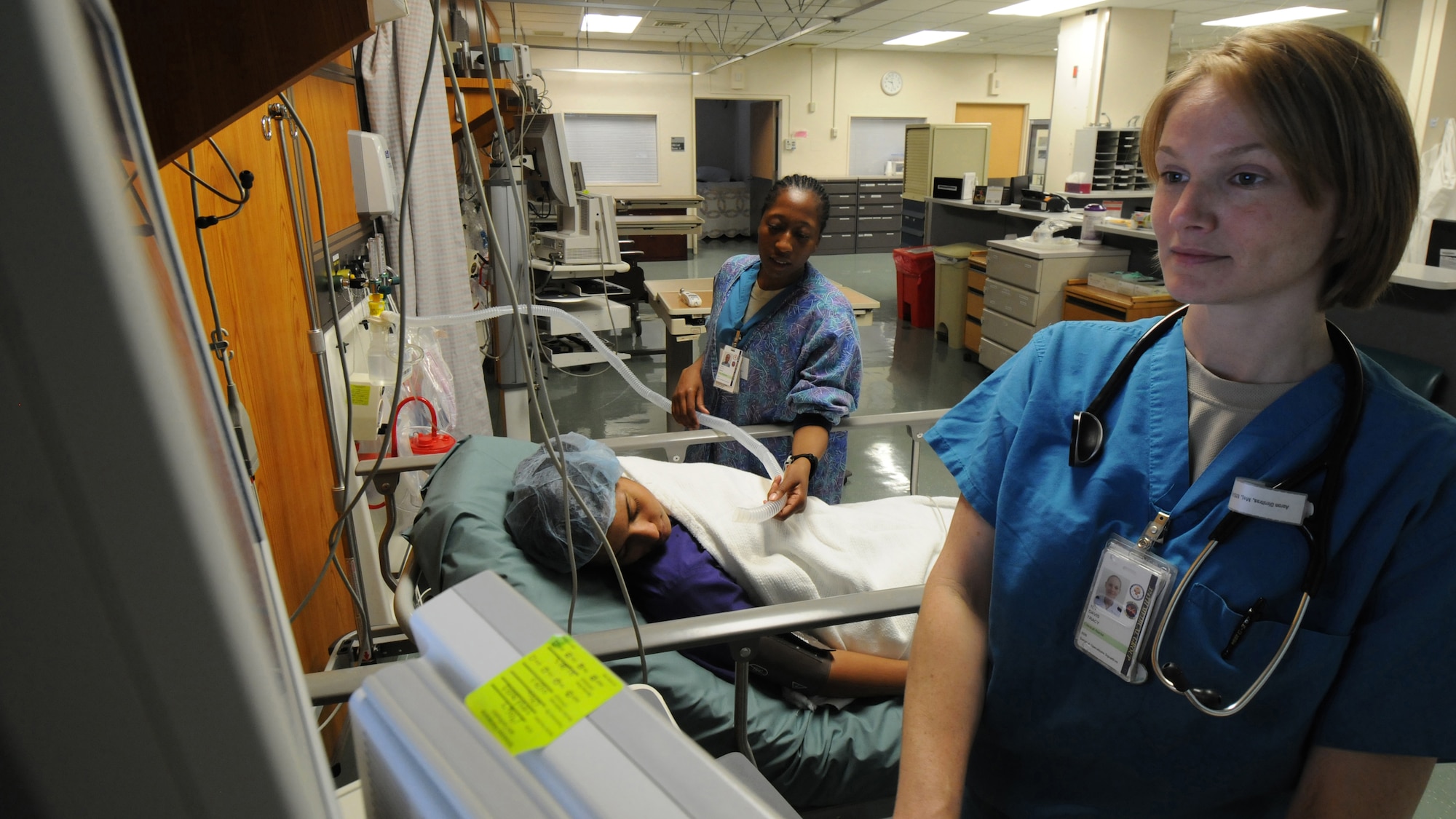YOKOTA AIR BASE, Japan -- 1st Lt. Tracy Davis (right), 374th Surgical Operations Squadron  Same Day Surgery Unit clinical nurse, and Staff Sgt. Eboni Scott, 374th MSGS Same Day Surgery Unit medical technician, simulate post-surgery care on Senior Airman Yethzurys Brown, 374th MSGS medical technician, at Yokota Air Base, June 17, 2011. The unit handles pre- and post-surgery patient care to include checking vital signs, administering IVs and patient discharges. (U.S. Air Force photo/Airman John D. Partlow)
