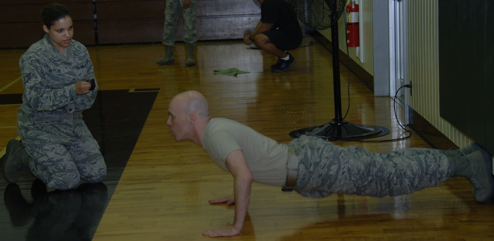 YOKOTA AIR BASE, Japan -- Staff Sgt. Patrice Settles, 374th Maintenance Operation Squadron, counts push-ups for Staff Sgt. Brandon Peck, 374th MOS maintenance analysis and database manager section chief, during a push-up competition at the Samurai Fitness Center at Yokota Air Base, Japan, June 16, 2011. During the competition, contestants had ten minutes to complete as many push-ups as they could. Sponsors donated money based on the number of push-ups accomplished by each contestant, raising money for the Yokota Chiefs' Group and the Enlisted Village. (U.S. Air Force photo/Airman 1st Class Lynsie Nichols)