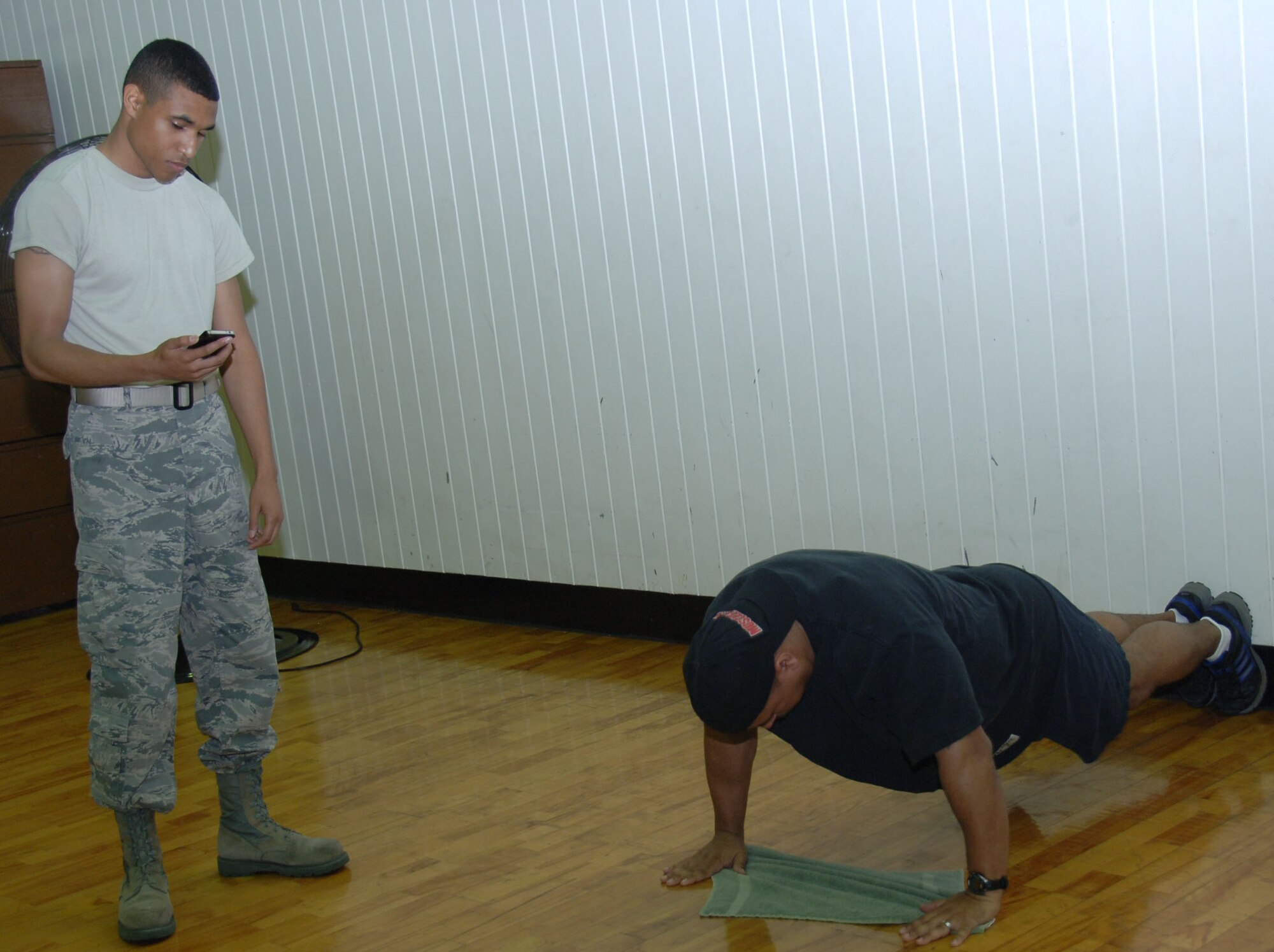 YOKOTA AIR BASE, Japan -- Airman 1st Class Juan Vargas, 374th Logistics Readiness Squadron equipment custodian, counts push-ups for Master Sgt. Chris Valenzuela, 374th LRS individual protective equipment section chief, during a push-up competition at the Samurai Fitness Center at Yokota Air Base, Japan, June 16, 2011. During the competition, contestants had ten minutes to complete as many push-ups as they could. Sponsors donated money based on the number of push-ups accomplished by each contestant, raising money for the Yokota Chiefs' Group and the Enlisted Village. (U.S. Air Force photo/Airman 1st Class Lynsie Nichols)


